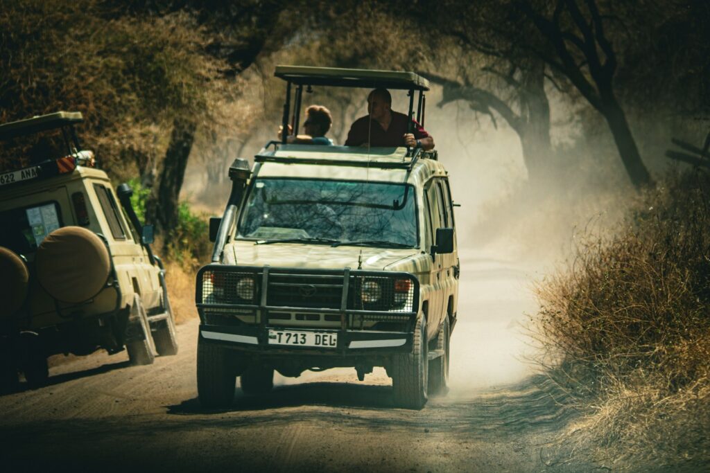 a safari vehicle driving down a dirt road